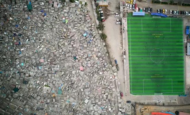 Residents play soccer alongside the Belaunde cemetery in the Comas neighborhood in Lima, Peru, Sunday, July 12, 2026. (AP Photo/Martin Mejia)