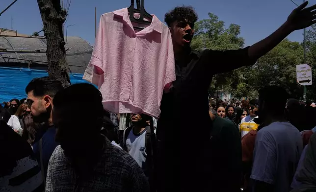 A vendor advertises clothing at Tehran's traditional main bazaar, Iran, Thursday, July 16, 2026. (AP Photo/Vahid Salemi)
