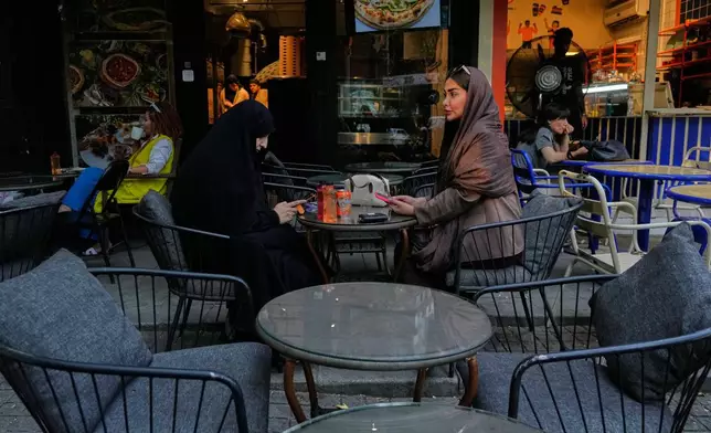 People sit at the outside areas of cafes in northern Tehran, Iran, Monday, July 13, 2026. (AP Photo/Vahid Salemi)