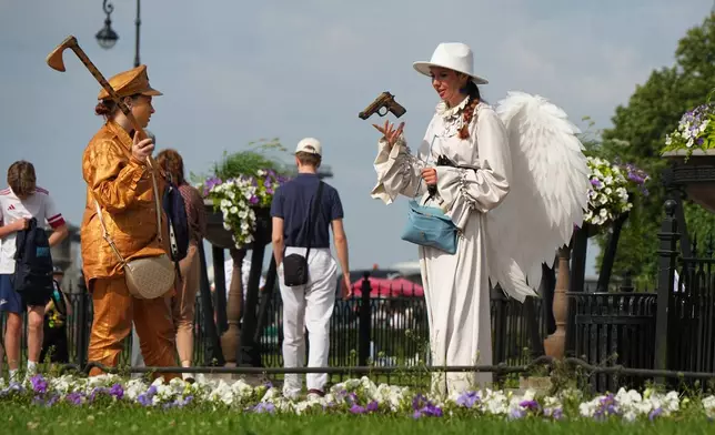 A street performer wearing an angel costume plays with a toy gun in central St. Petersburg, Russia, Wednesday, July 15, 2026. (AP Photo/Dmitri Lovetsky)
