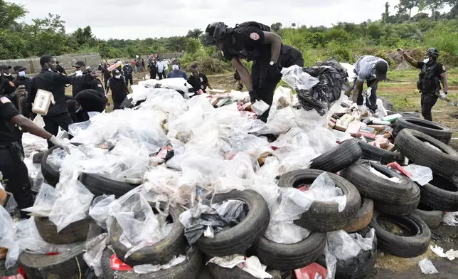 Liberian law enforcement agency officials prepare to burn cocaine consignments in Caraysburg in the outskirts of Monrovia, Liberia, Thursday, July 30, 2026. (AP Photo/Alexander Wiaplah)