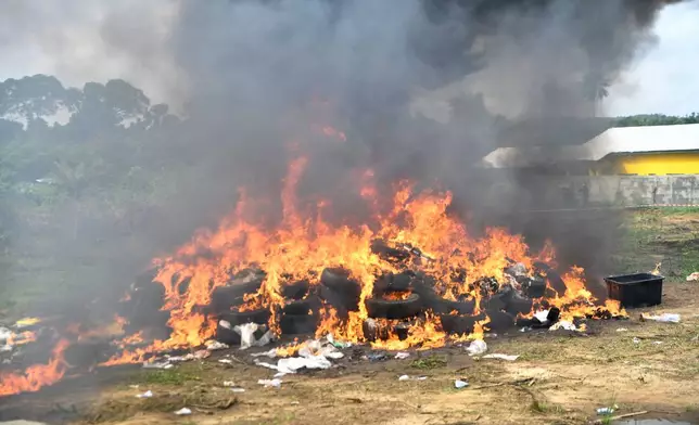 Liberian law enforcement agency burn seized cocaine in Caraysburg, Liberia, northeast of Monrovia, Thursday, July 30, 2026. (AP Photo/Alexander Wiaplah)