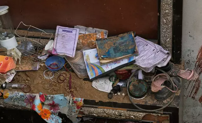 Books, shoes and other stuff of victim children are seen at the site of Tuesday's roof collapse at a tutoring center roof, on the outskirts of Lahore, Pakistan, Wednesday, July 1, 2026. (AP Photo/K.M. Chaudary)