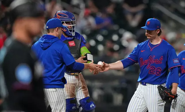 New York Mets pitcher Nolan McLean hands the ball to interim manager Andy Green as he leaves during the seventh inning of a baseball game against the Miami Marlins Thursday, July 30, 2026, in New York. (AP Photo/Frank Franklin II)