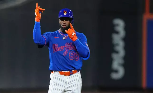 New York Mets' Luis Robert Jr. gestures to teammates after hitting a two-run single during the eighth inning of a baseball game against the Miami Marlins Thursday, July 30, 2026, in New York. (AP Photo/Frank Franklin II)