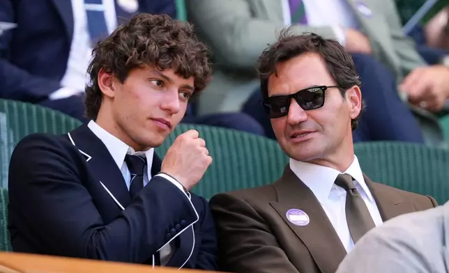 F1 Mercedes driver Andrea Kimi Antonelli of Italy sits beside former tennis player Roger Federer of Switzerland in the Royal Box on day eight at the Wimbledon Tennis Championships in London, Monday, July 6, 2026.(AP Photo/Kirsty Wigglesworth)