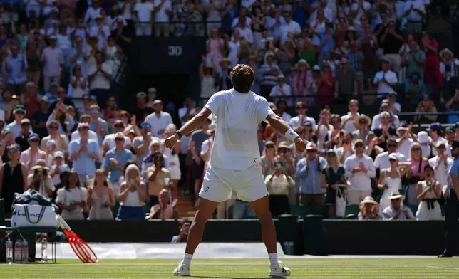 Flavio Cobolli of Italy celebrates winning against Alex de Minaur of Australia in their fourth round men's singles match at the Wimbledon Tennis Championships in London, Monday, July 6, 2026. (AP Photo/Maja Smiejkowska)
