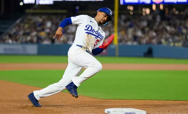 Los Angeles Dodgers' Mookie Betts rounds third base to score on an RBI single by Max Muncy during the fourth inning of a baseball game against the San Diego Padres in Los Angeles, Thursday, July 2, 2026. (AP Photo/Kyusung Gong)