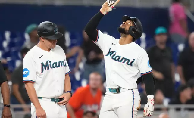 Miami Marlins' Otto Lopez, right, reacts after hitting a triple to break a franchise record with the most hits before the All Star break during the fourth inning of a baseball game against the Seattle Mariners, Thursday, July 9, 2026, in Miami. (AP Photo/Lynne Sladky)