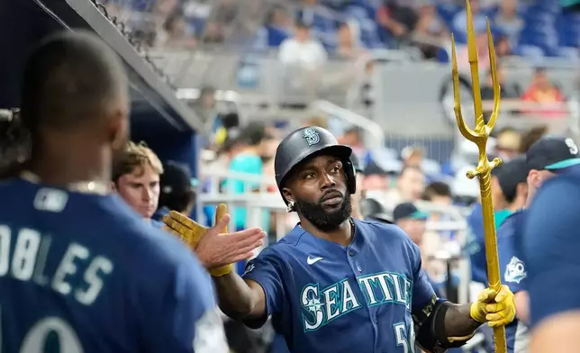 Seattle Mariners' Randy Arozarena (56) is congratulated in the dugout after hitting a solo home run during the fifth inning of a baseball game against the Miami Marlins, Thursday, July 9, 2026, in Miami. (AP Photo/Lynne Sladky)