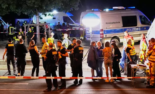 Emergency personnel and police gather in Berlin, early Sunday, July 26, 2026, following the cancellation of Christopher Street Day festivities. (AP Photo/Ebrahim Noroozi)