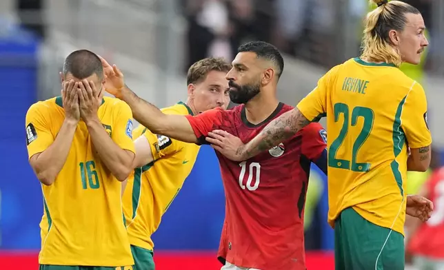 Egypt's Mohamed Salah (10) comforts Australia's Aziz Behich after Australia lost a penalty shootout following their World Cup round of 32 soccer match in Arlington, Texas, near Dallas, Friday, July 3, 2026. (AP Photo/Julio Cortez)