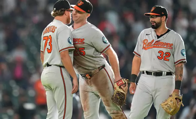 Baltimore Orioles relief pitcher Cam Sanders, left, celebrates with Pete Alonso, center, and Christian Encarnacion-Strand, right, after a baseball game against the Houston Astros, Saturday, July 18, 2026, in Houston. (AP Photo/Karen Warren)