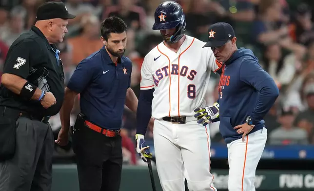 Houston Astros' Christian Walker is taken back to the clubhouse by a trainer and manager Joe Espada without finishing his at bat against Baltimore Orioles starting pitcher Trevor Rogers during the fourth inning of a baseball game, Saturday, July 18, 2026, in Houston. (AP Photo/Karen Warren)