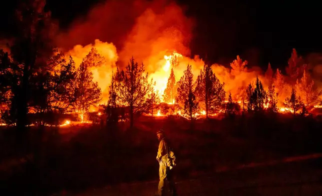 FILE - A firefighter monitors a firing operation while battling a wildfire called the Bench Fire in Warm Springs, Ore., July 25, 2026. (AP Photo/Noah Berger, File)
