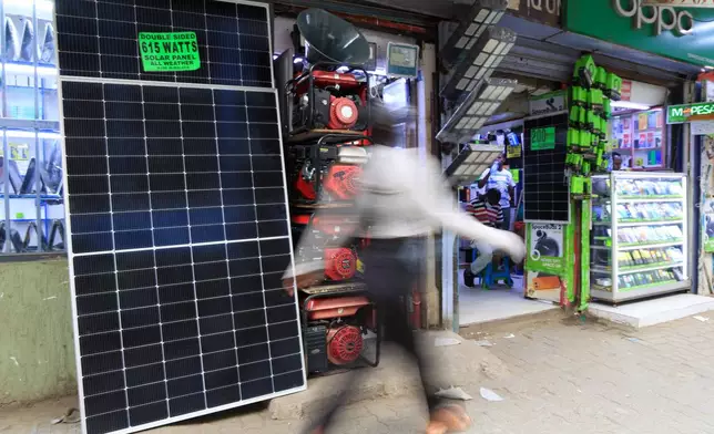 A man walks past solar panels displayed for sale in Nairobi, Kenya, Tuesday, July 16, 2026. (AP Photo/Andrew Kasuku)