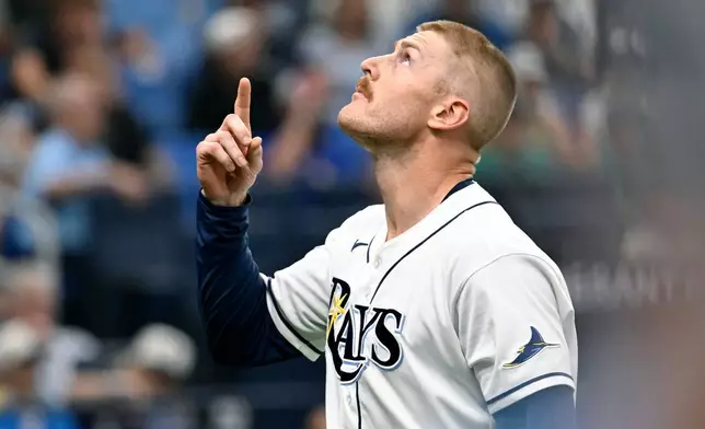Tampa Bay Rays pitcher Cam Booser celebrates as he comes to the dugout after striking out Seattle Mariners' J.P. Crawford during the seventh inning of a baseball game Saturday, July 11, 2026, in St. Petersburg, Fla. (AP Photo/Jason Behnken)