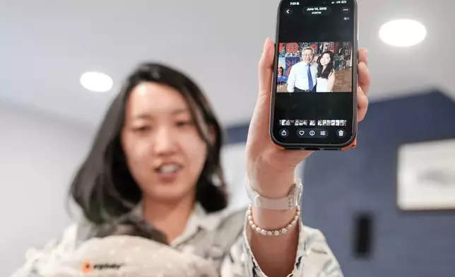 Grace Jin Drexel shows the old photos of her father after an interview with The Associated Press in Maryland, Wednesday, July 22, 2026 . (AP Photo/Mariam Zuhaib)