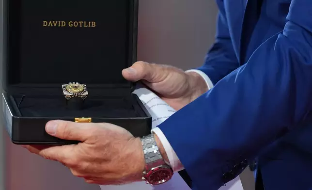 U.S. Ambassador to Belgium Bill White presents a ring designed for U.S. President Donald Trump and crafted by Antwerp diamond designer David Gotlib, during the America 250 event in Brussels, Sunday, June 28, 2026. (AP Photo/Virginia Mayo)