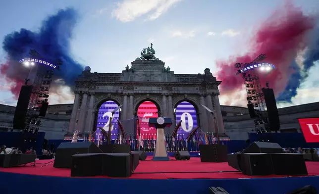 Colored smoke is lit behind the Cinquantenaire Arch to celebrate during the America 250 event in Brussels, Sunday, June 28, 2026. (AP Photo/Virginia Mayo)