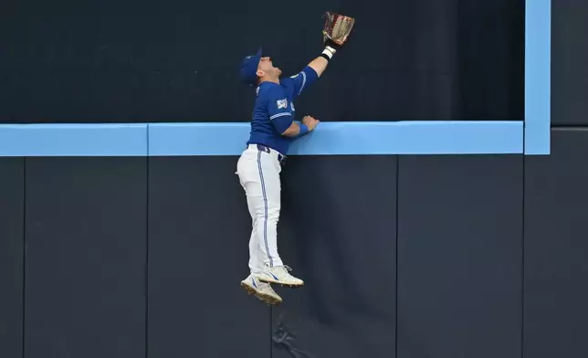 Toronto Blue Jays outfielder Daulton Varsho is unable to catch a home run off the bat of Tampa Bay Rays' Victor Mesa Jr. during the second inning of a baseball game in Toronto, Monday, July 20, 2026. (Jon Blacker/The Canadian Press via AP)