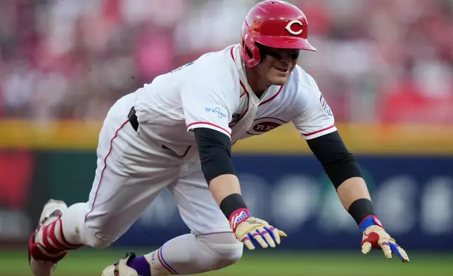 Cincinnati Reds' TJ Friedl dives into third base for a triple to score Jose Trevino during the second inning of a baseball game against the Baltimore Orioles in Cincinnati, Saturday, July 4, 2026. (AP Photo/Carolyn Kaster)