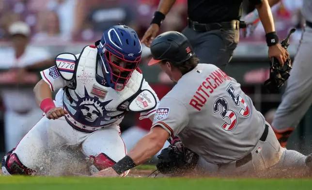 Baltimore Orioles Adley Rutschman, right, is tagged out by Cincinnati Reds catcher Jose Trevino, left, during the third inning of a baseball game in Cincinnati, Saturday, July 4, 2026. (AP Photo/Carolyn Kaster)