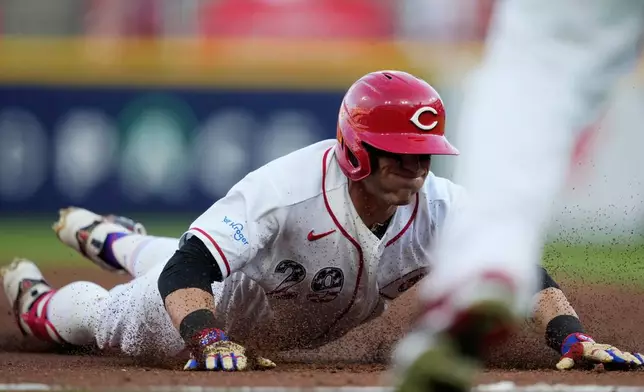 Cincinnati Reds' TJ Friedl dives into third base for a triple to score Jose Trevino during the second inning of a baseball game against the Baltimore Orioles in Cincinnati, Saturday, July 4, 2026. (AP Photo/Carolyn Kaster)