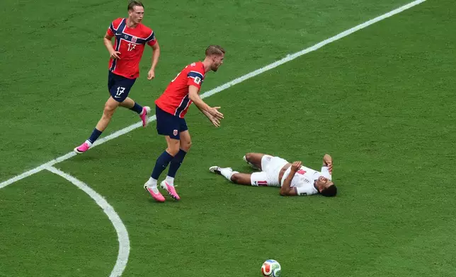 England's Jude Bellingham (10) is knocked down competing as Norway's Kristoffer Ajer (3) and Torbjoern Heggem (17) react to the play during the World Cup quarterfinal soccer match between Norway and England in Miami Gardens, Fla., Saturday, July 11, 2026. (AP Photo/Marta Lavandier)
