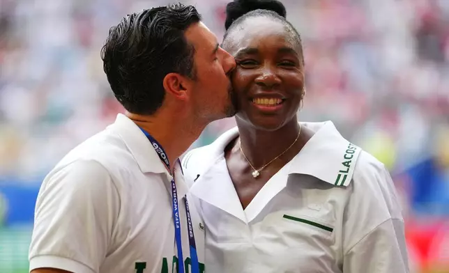 Andrea Preti kisses his wife U.S. tennis player on the field prior to a World Cup quarterfinal soccer match between England and Norway in Miami Gardens, Fla., Saturday, July 11, 2026. (AP Photo/Julio Cortez)