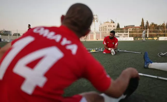 Players from Omayya Club stretch before the final of Syria's first football tournament for people with disabilities at Al-Muhafaza Stadium in Damascus, Syria, Wednesday, July 29, 2026. (AP Photo/Ghaith Alsayed)