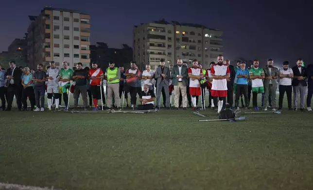 Players, coaches and officials pray before the final of Syria's first football tournament for people with disabilities at Al-Muhafaza Stadium in Damascus, Syria, Wednesday, July 29, 2026. (AP Photo/Ghaith Alsayed)