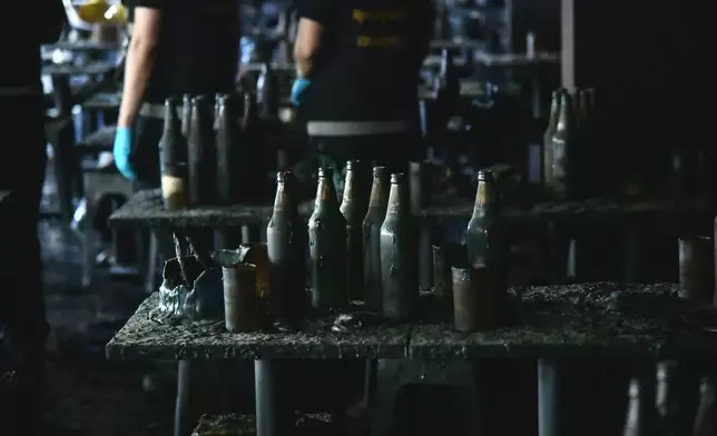 In this handout photo released by Bangkok Metropolitan Administration, bottles are seen on a table at the site of a fire in Bangkok, Thailand, Monday, July 13, 2026. (Bangkok Metropolitan Administration via AP)