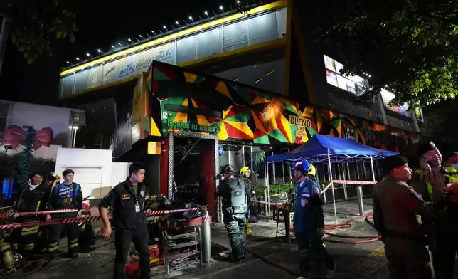 Rescuers stand near the site of a fire in Bangkok, Thailand, Monday, July 13, 2026. (AP Photo/Sakchai Lalit)
