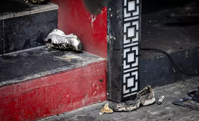 Burnt shoes are left outside the music bar where a fire killed a number of people in Bangkok, Thailand, Tuesday, July 14, 2026. (AP Photo/Wason Wanichakorn)