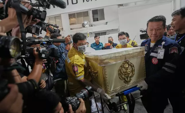 A coffin of a victim in a music bar fire is prepared to be handed over to the relatives, unseen, at a police hospital in Bangkok, Thailand, Tuesday, July 14, 2026. (AP Photo/Sakchai Lalit)