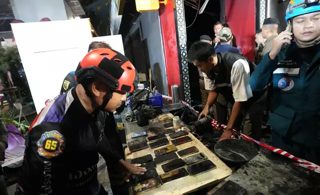 Mobile phones of victims of a fire are recovered in Bangkok, Thailand, Monday, July 13, 2026. (AP Photo/Sakchai Lalit)