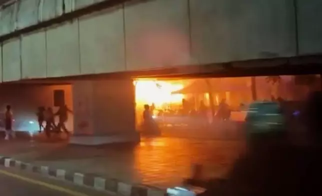 In this image made from video provided by Instagram handle @jackfanchan, people move around a fire at a bar in Bangkok, Thailand, Monday, July 13, 2026. (@jackfanchan via AP)