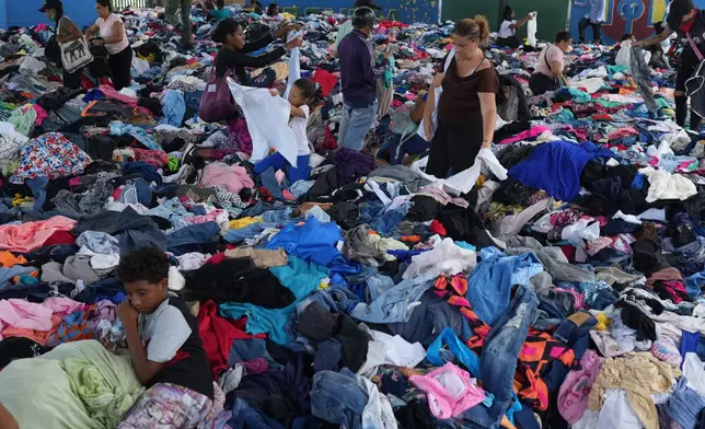 People choose clothes donated to those affected by the earthquakes at a sports complex in La Guaira, Venezuela, Saturday, July 4, 2026. (AP Photo/Ariana Cubillos)