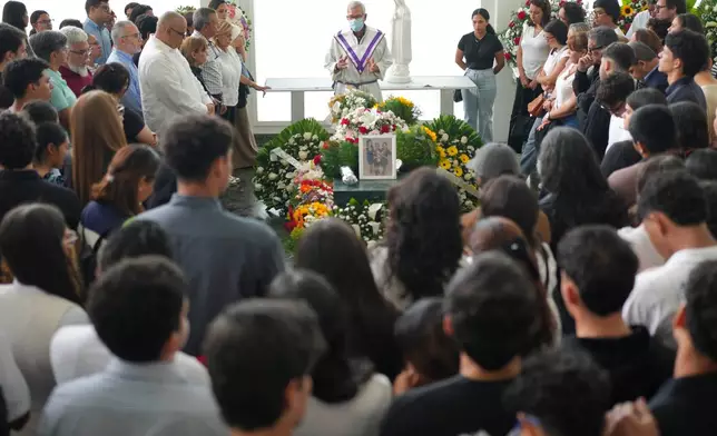 Relatives and friends attend the funeral Mass for Daniela Mora, her mother, Maria Cruz, and her grandmother, Judith Padron, who died when their apartment building collapsed during the earthquake in the San Bernardino neighborhood of Caracas, Venezuela, Saturday, July 4, 2026. (AP Photo/Matias Delacroix)