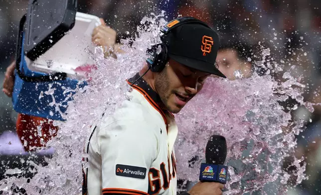 San Francisco Giants' Grant McCray is doused by teammates after their team's victory over the Milwaukee Brewers during a baseball game in San Francisco, Monday, July 27, 2026. (AP Photo/Jed Jacobsohn)