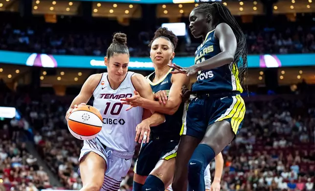 Toronto Tempo's Maria Conde (10) drives past Dallas Wings' Awak Kuier (34) and Azzi Fudd (35) during first half of a WNBA basketball game, in Montreal on Friday, July 10, 2026. (Christopher Katsarov/The Canadian Press via AP)
