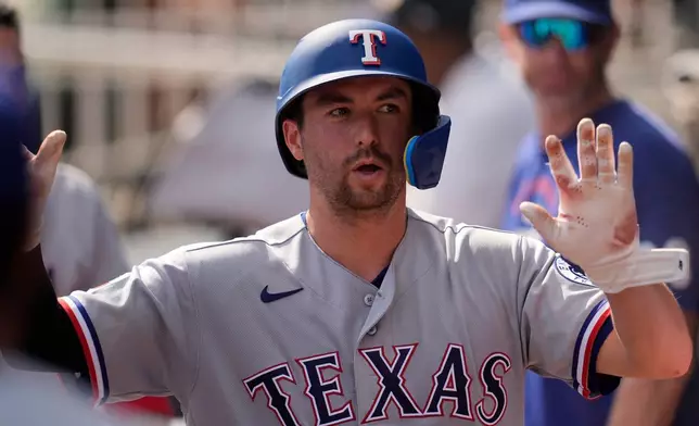 Texas Rangers catcher Kyle Higashioka (11) celebrates scoring off the bat of Wyatt Langford in the third inning of a baseball game against the Atlanta Braves, Saturday, July 18, 2026, in Atlanta. (AP Photo/Mike Stewart)