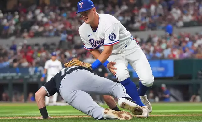 Texas Rangers third baseman Josh Jung, right, tags out Chicago White Sox's Sam Antonacci, left, between third and home plate on a fielder's choice during the first inning of a baseball game, Monday, July 20, 2026, in Arlington, Texas. (AP Photo/LM Otero)