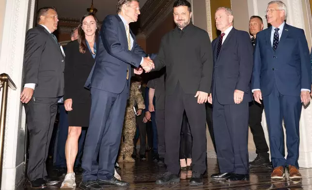 Ukraine's President Volodymyr Zelenskyy stands with a bipartisan group of Senators in the Capitol building, Tuesday, July 28, 2026, in Washington. (AP Photo/Allison Robbert)
