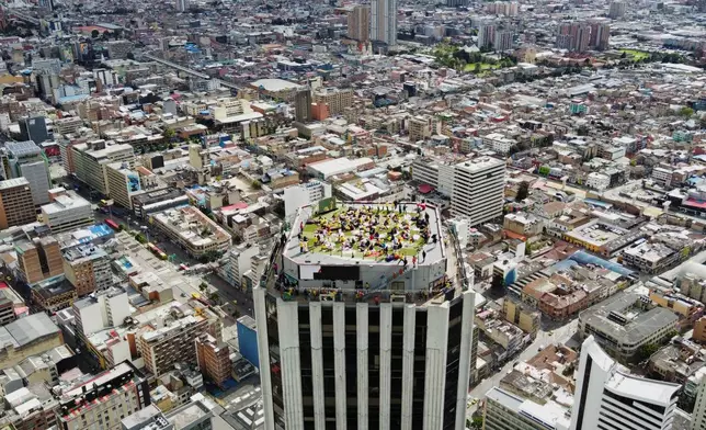 Fans watch the World Cup round of 16 soccer match between Colombia and Switzerland on a terrace rooftop in Bogota, Colombia, Tuesday, July 7, 2026. (AP Photo/Sebastian Barros)