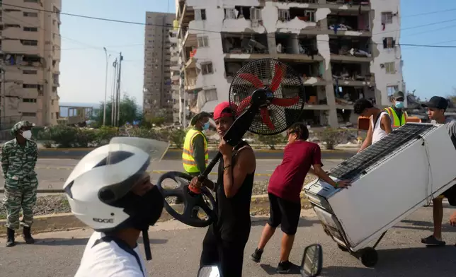 Residents recover items from homes damaged during the earthquakes in La Guaira, Venezuela, Monday, July 6, 2026. (AP Photo/Ariana Cubillos)