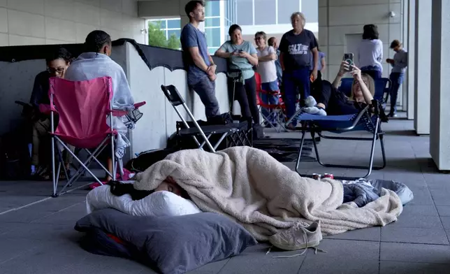 A woman sleeps outside the courthouse in hopes to get access to the limited public seating available at a preliminary hearing for Tyler Robinson, the Utah man accused of fatally shooting Charlie Kirk, in Provo, Utah, Thursday, July 9, 2026. (AP Photo/Ty ONeil)