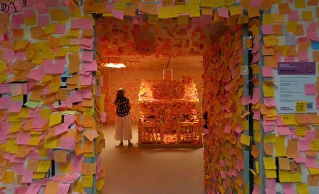 A visitor stands in the Gratitude Room, which is covered with handwritten notes, during the "Hospital of Emotions" exhibition inside a former hospital building in Los Angeles, Wednesday, July 22, 2026.(AP Photo/Jae C. Hong)