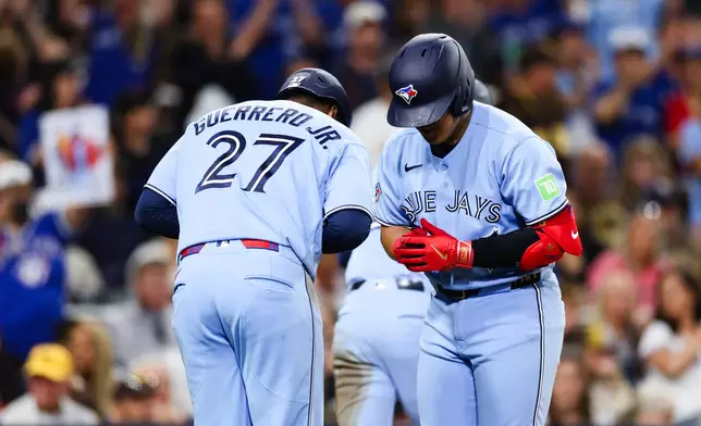 Toronto Blue Jays' Kazuma Okamoto, right, and Vladimir Guerrero Jr. celebrate after he hit a three-run home run against the San Diego Padres in the fifth inning of a baseball game Friday, July 10, 2026, in San Diego. (AP Photo/Derrick Tuskan)